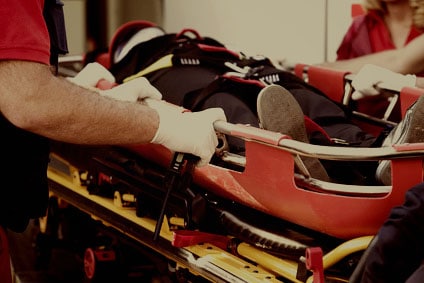 paramedics rushing patient into an ambulance